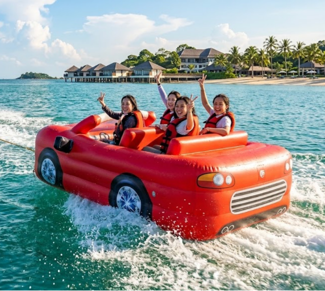 A group of friends excitedly ride the Lightning McQueen towable inflatable, shaped like a red